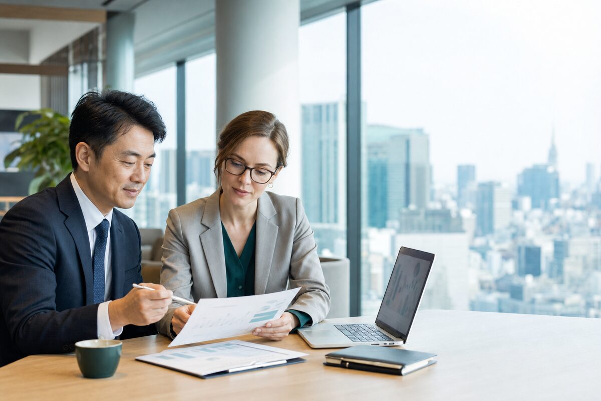 An accountant and a finance manager reviewing a financial report together in a Tokyo office